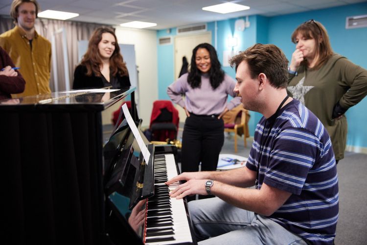 Music Therapy students in class around a piano